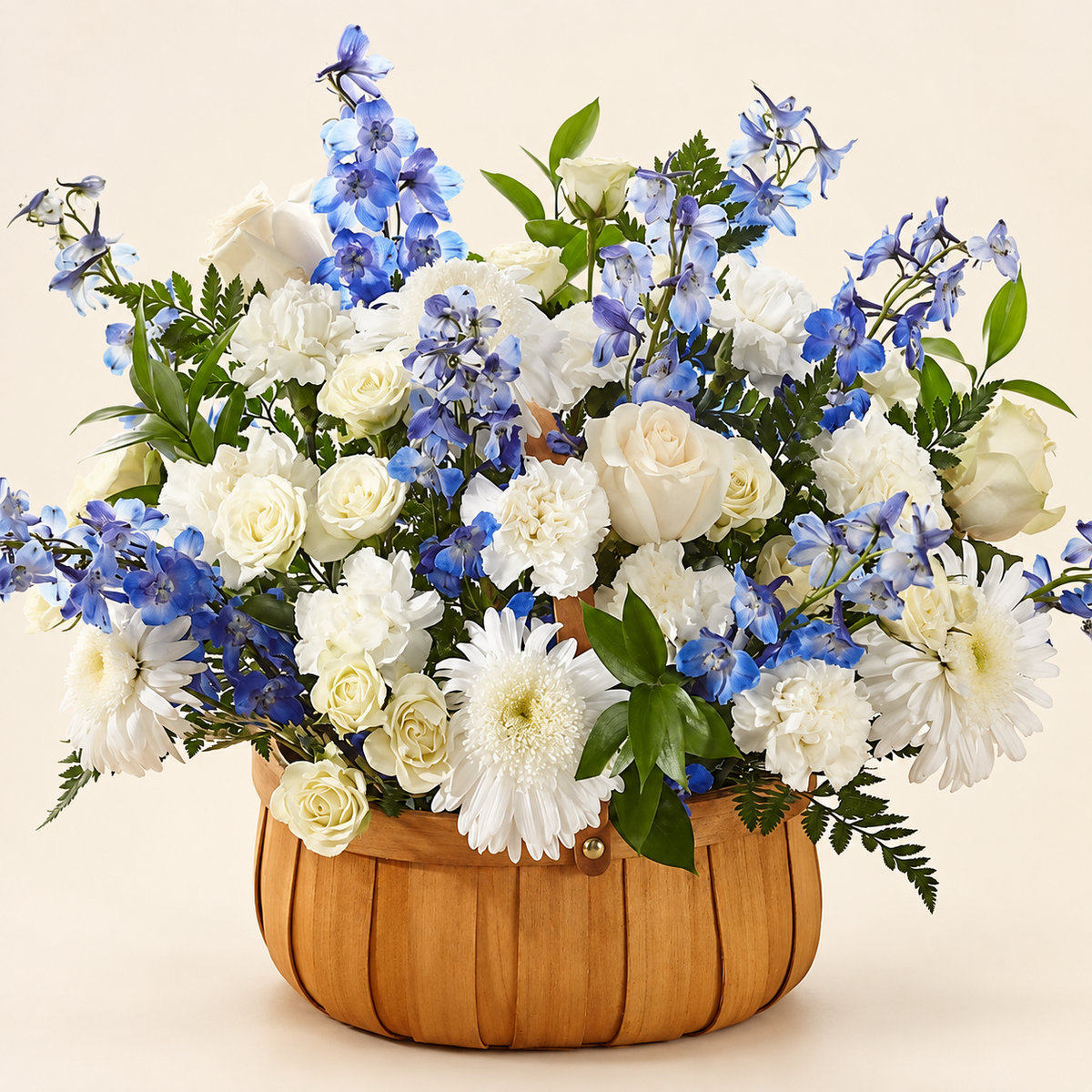 Full white and blue sympathy basket with roses, spray roses, delphinium and greenery in a woven basket, handcrafted by Baldwin Park florist