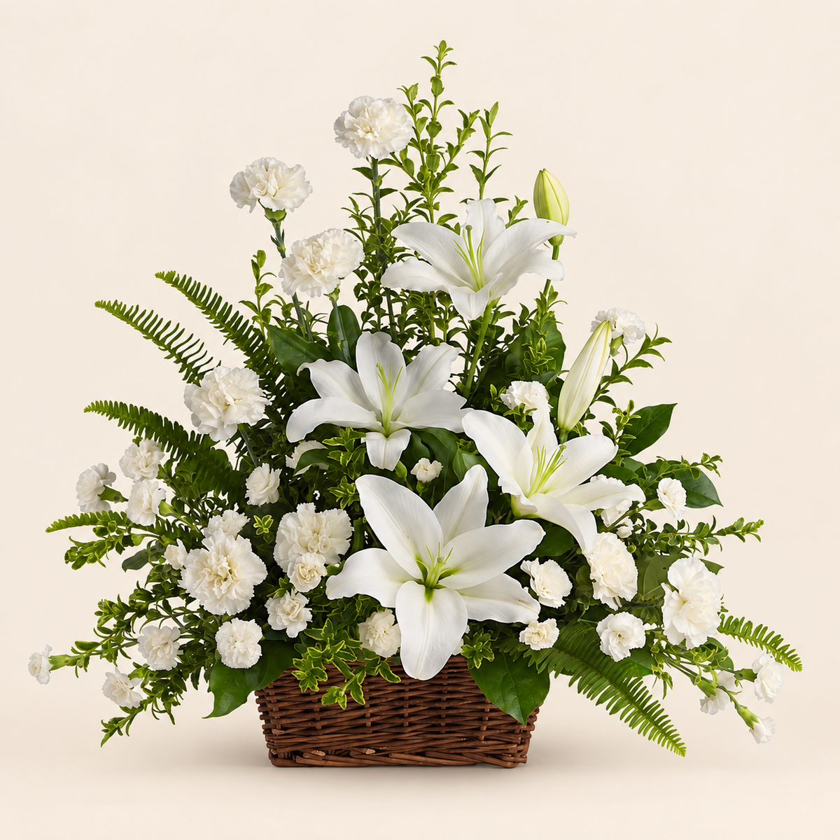 Peaceful white lily sympathy basket with carnations and seasonal greenery in a wicker basket