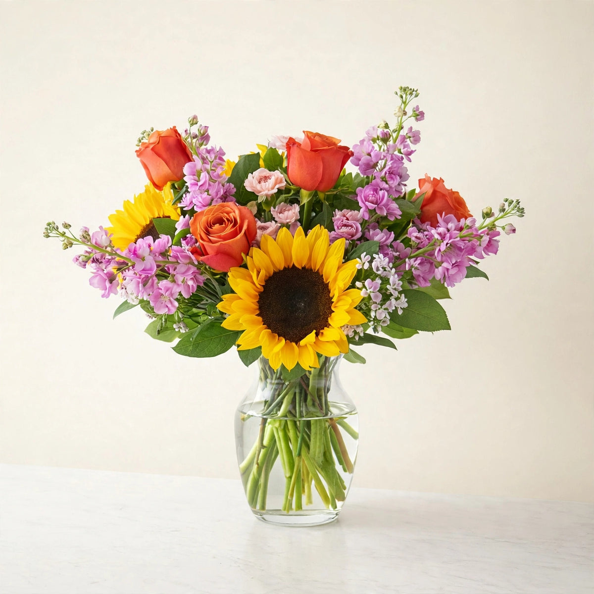 Yellow Brick Road Bouquet — sunflowers with roses and seasonal blooms in a clear glass vase, hand-arranged by LaLa Florist in Baldwin Park, side view