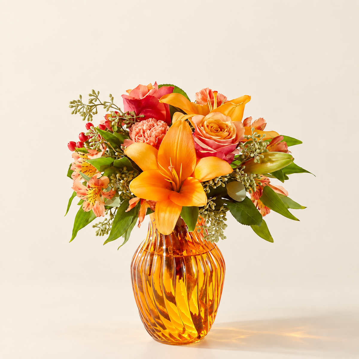 Afternoon Light bouquet with orange roses and lilies in amber vase, front view
