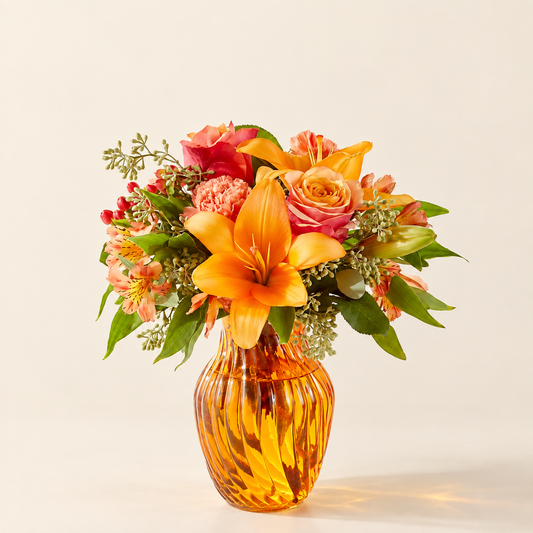 Afternoon Light bouquet with orange roses and lilies in amber vase, front view
