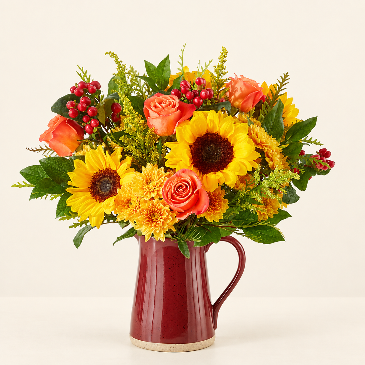 Scents of Autumn bouquet with hypericum berries and solidago in a keepsake red vase
