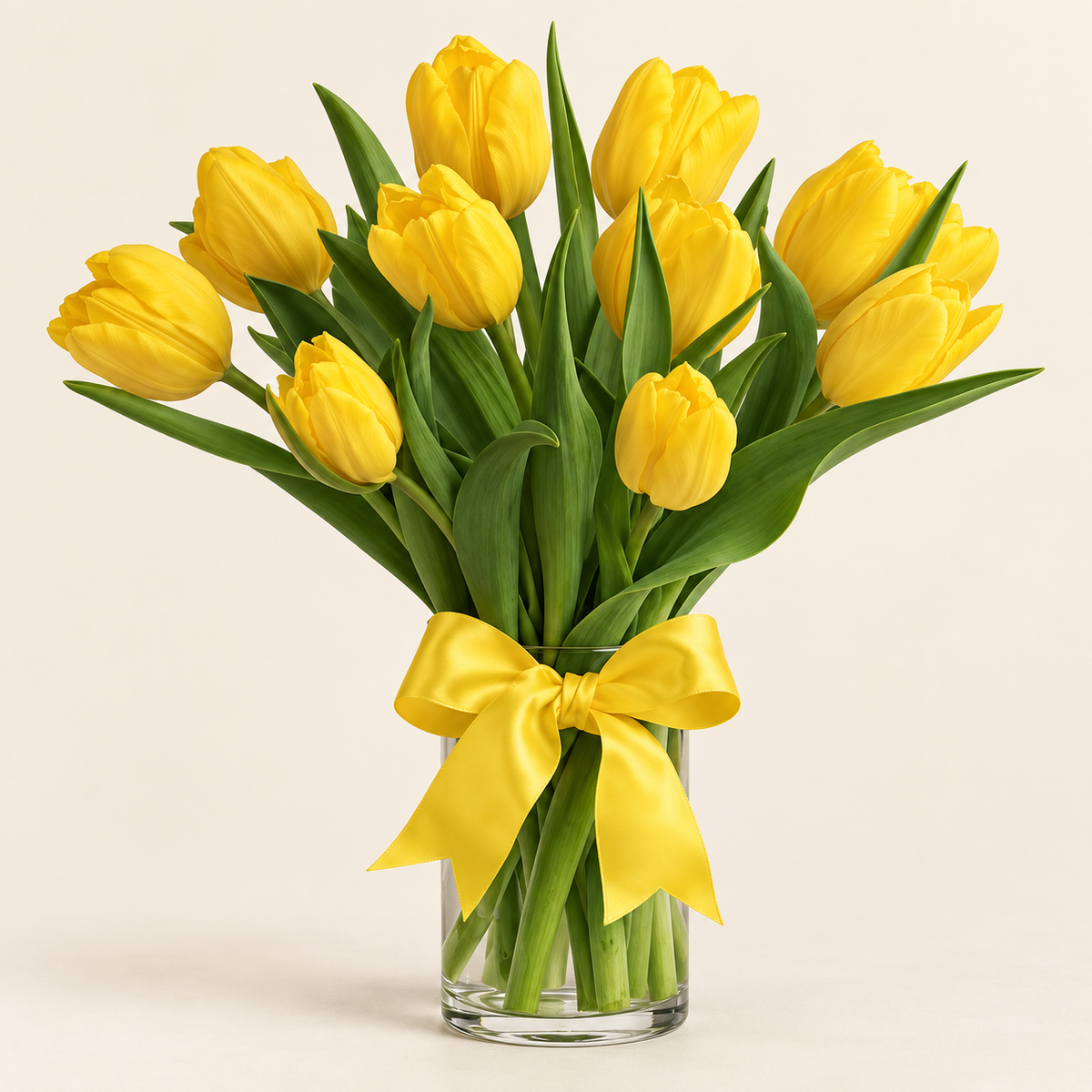 Sunny yellow tulip vase with fresh yellow tulips tied with a yellow bow in a clear glass vase, hand-arranged by Baldwin Park florist