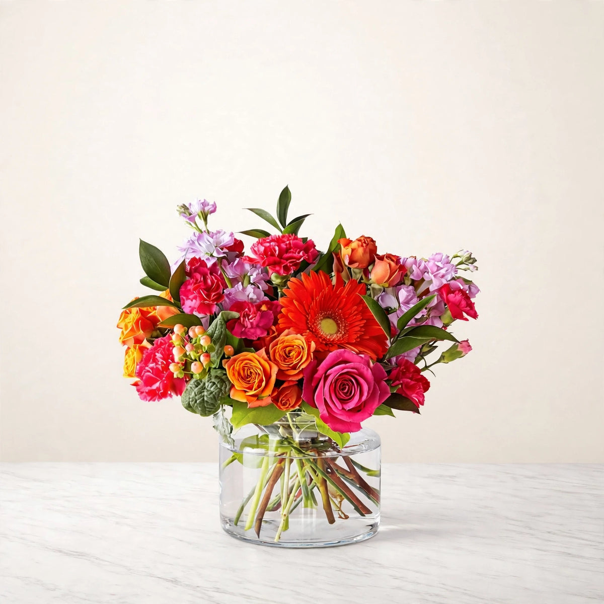 Fiesta Bouquet — orange gerbera daisies, orange and hot pink roses, pink carnations and orange spray roses in a clear glass vase, hand-arranged by LaLa Florist in Baldwin Park, alternate view
