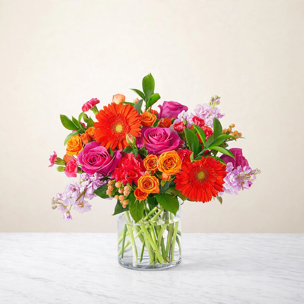 Fiesta Bouquet — orange gerbera daisies, orange and hot pink roses, pink carnations and orange spray roses in a clear glass vase, hand-arranged by LaLa Florist in Baldwin Park, side view