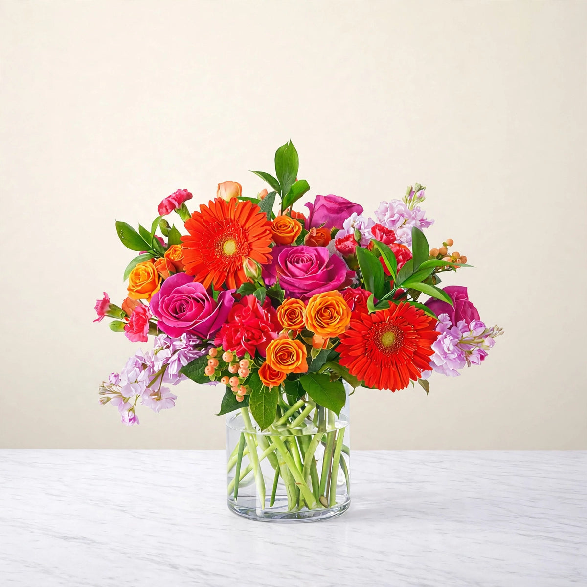 Fiesta Bouquet — orange gerbera daisies, orange and hot pink roses, pink carnations and orange spray roses in a clear glass vase, hand-arranged by LaLa Florist in Baldwin Park, close view