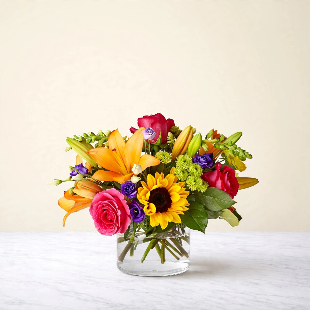 Best Day Bouquet — sunflowers, yellow lilies, hot pink roses, purple lisianthus and green hydrangea in a clear glass vase, hand-arranged by LaLa Florist in Baldwin Park, side view