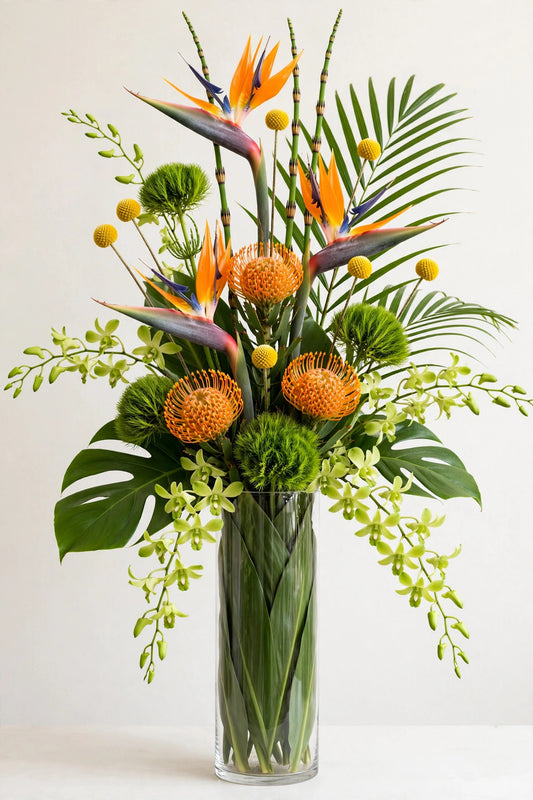 Paradise Flight Arrangement – bird of paradise and pincushion protea in a leaf-lined cylinder vase