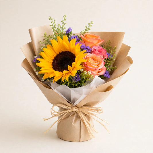 Sunshine Bloom Bouquet — a cheerful sunflower with soft peach roses and seasonal flowers in a kraft paper wrap, hand-arranged by LaLa Florist in Baldwin Park